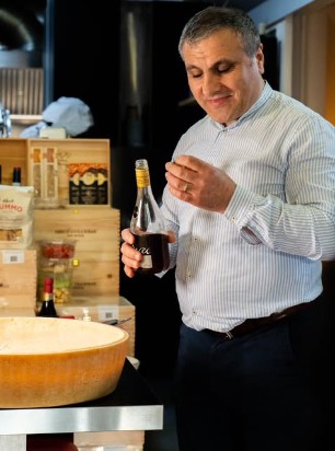 David, dans la trattoria Dolia Nova, une bouteille de vin italien à la main